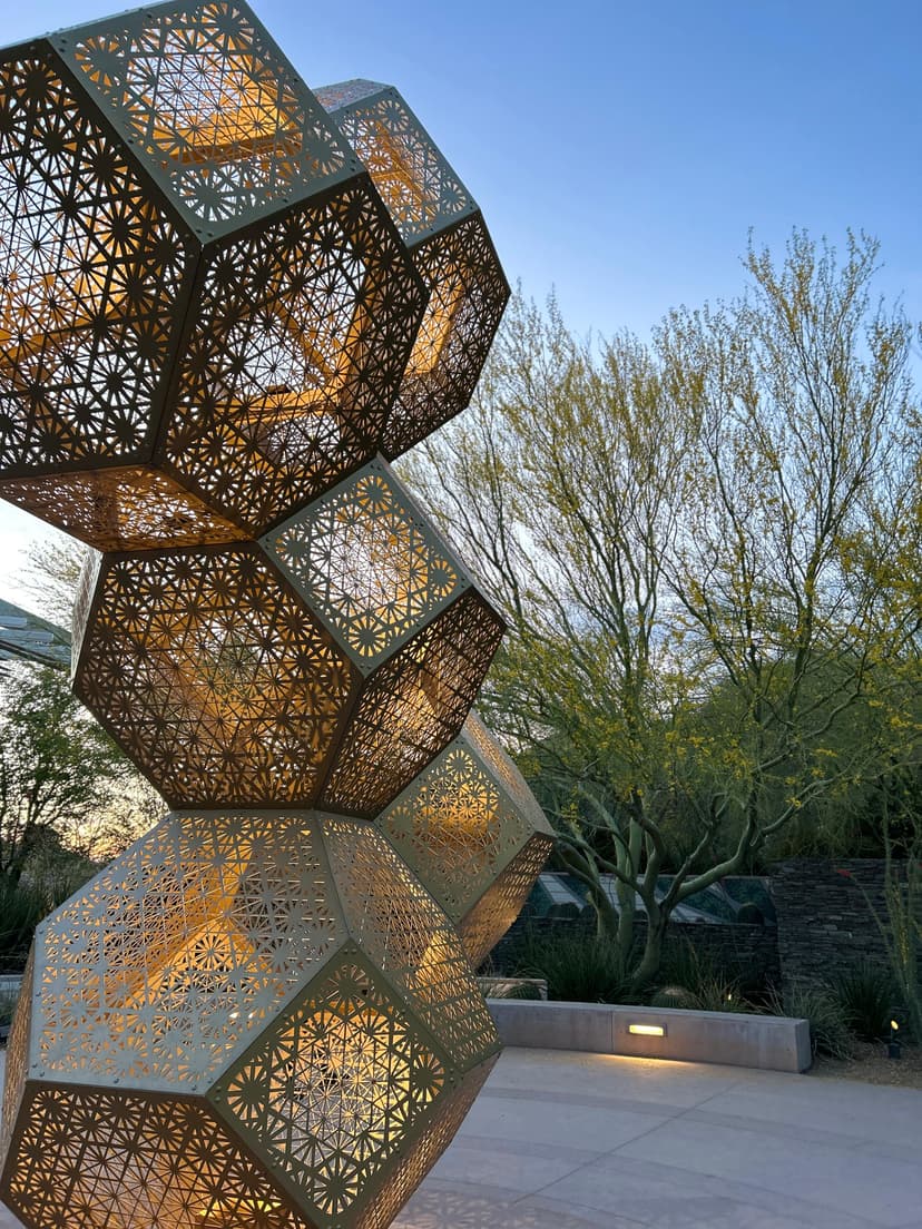 Intricate geometric sculpture glowing at dusk