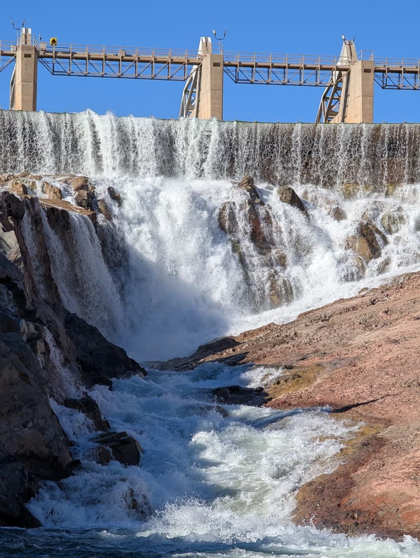 Waterfall cascading down from a hydro dam into rocky terrain