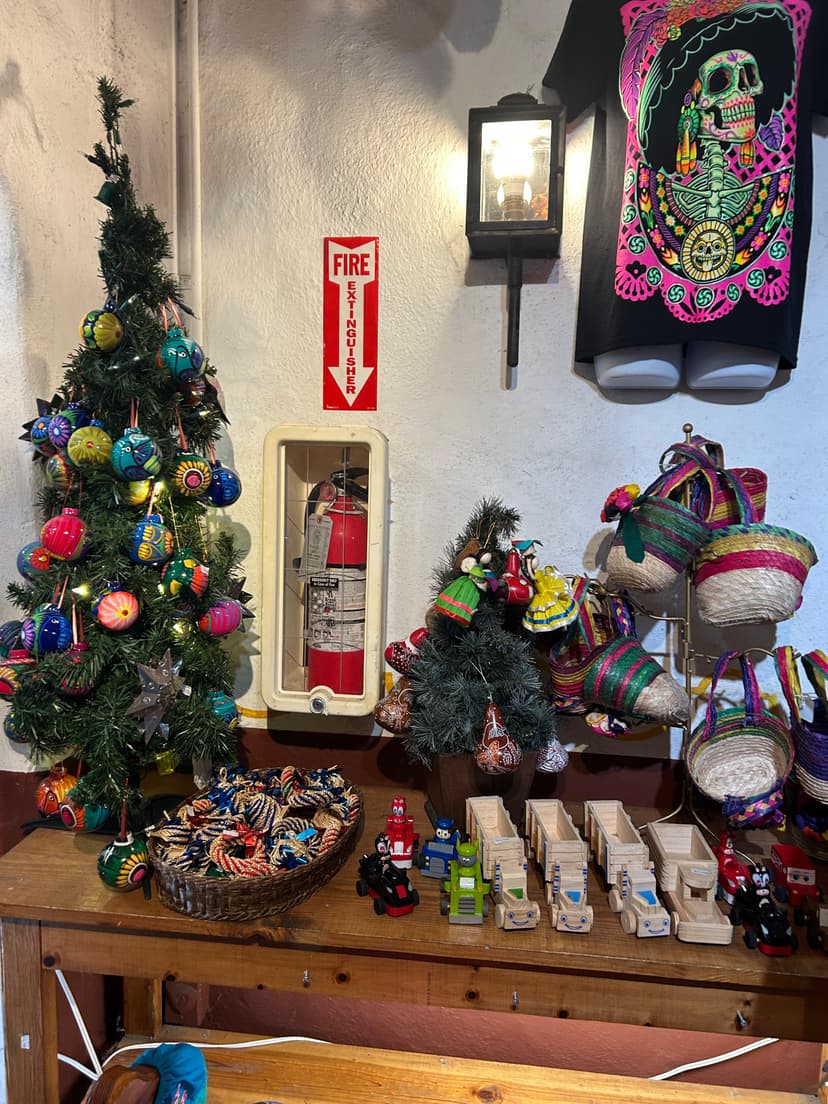 Colorful Mexican-themed decor with ornaments, baskets, and Christmas trees inside Old Town San Diego shop