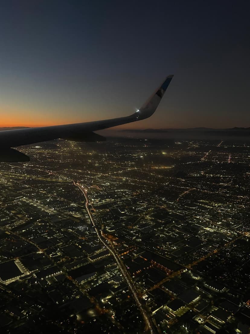 Aerial night view of Los Angeles city lights and streets from airplane window