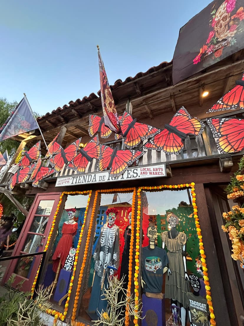 Storefront decorated with monarch butterflies and skeleton mannequins for Día de los Muertos