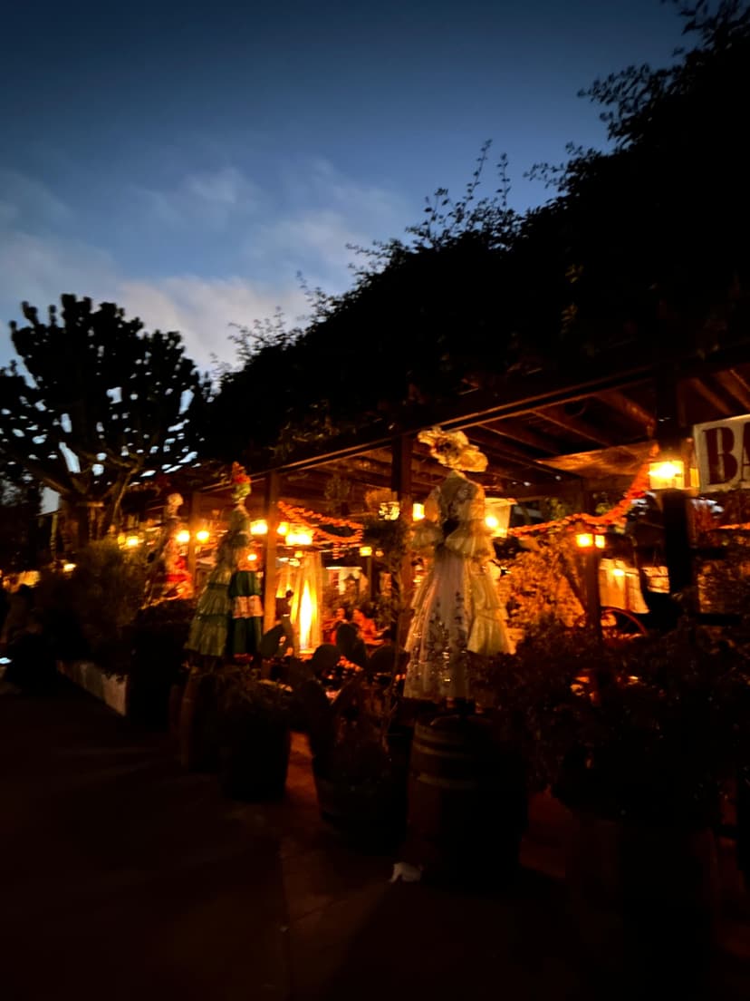 Warmly lit outdoor restaurant decorated with skeleton figures during evening celebration