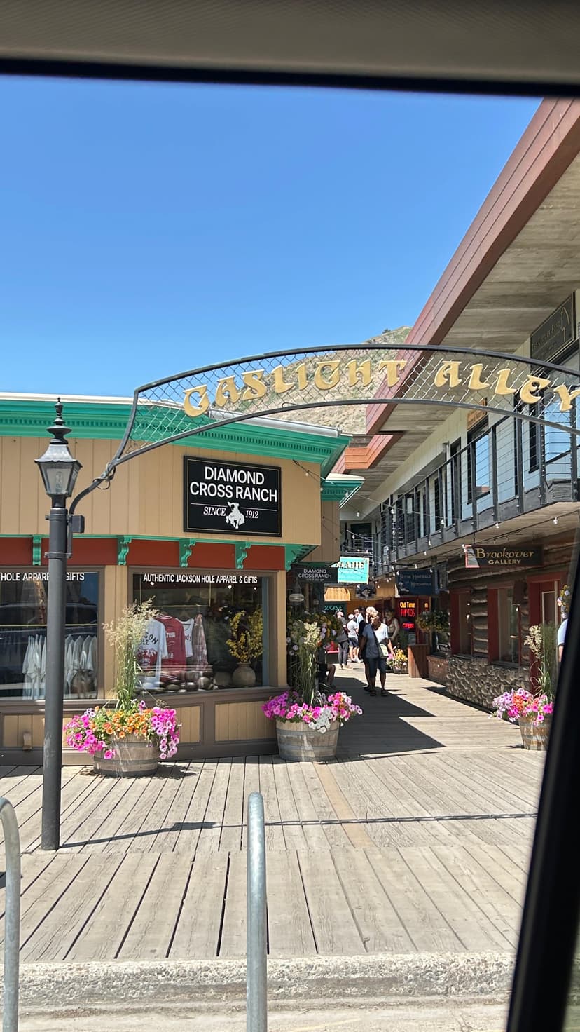 Charming Jackson Hole shopping street with Gaslight Alley sign and flower barrels